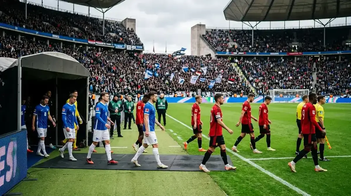 Imreoirí sacair ag dul amach ar an bpáirc roimh chluiche tráthnóna, soilse boga an staidiam